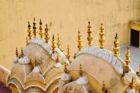Rooftop of building with golden domes, reflecting sunlight, adding elegance to architecture.