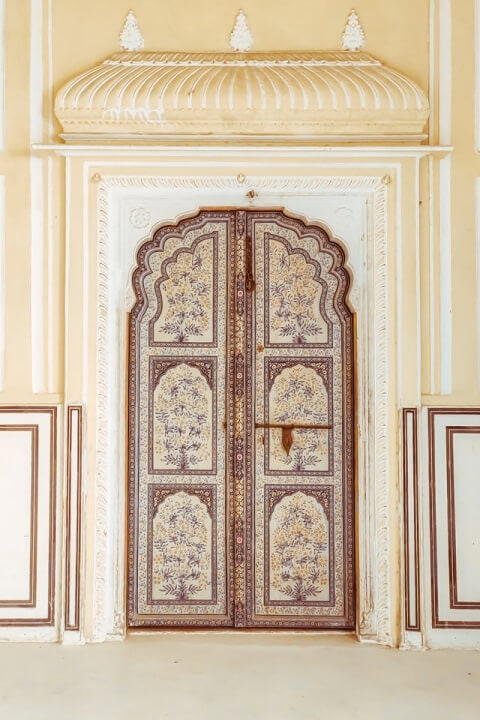 A white building door adorned with intricate designs.
