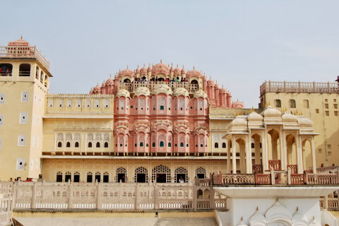 The Palace of the Winds in Jaipur, India, a stunning pink sandstone palace with intricate latticework windows.